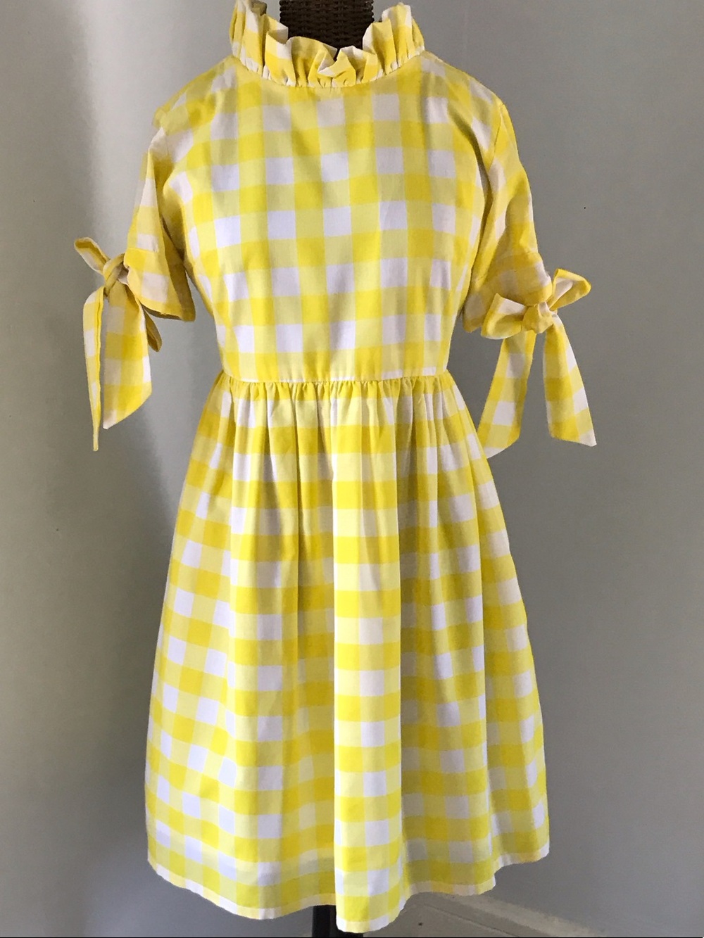 Elizabeth Wilson yellow gingham dress with ruffled neck and bow s sleeves.